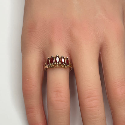 Vintage 10K gold ring with five marquise garnets on model’s hand