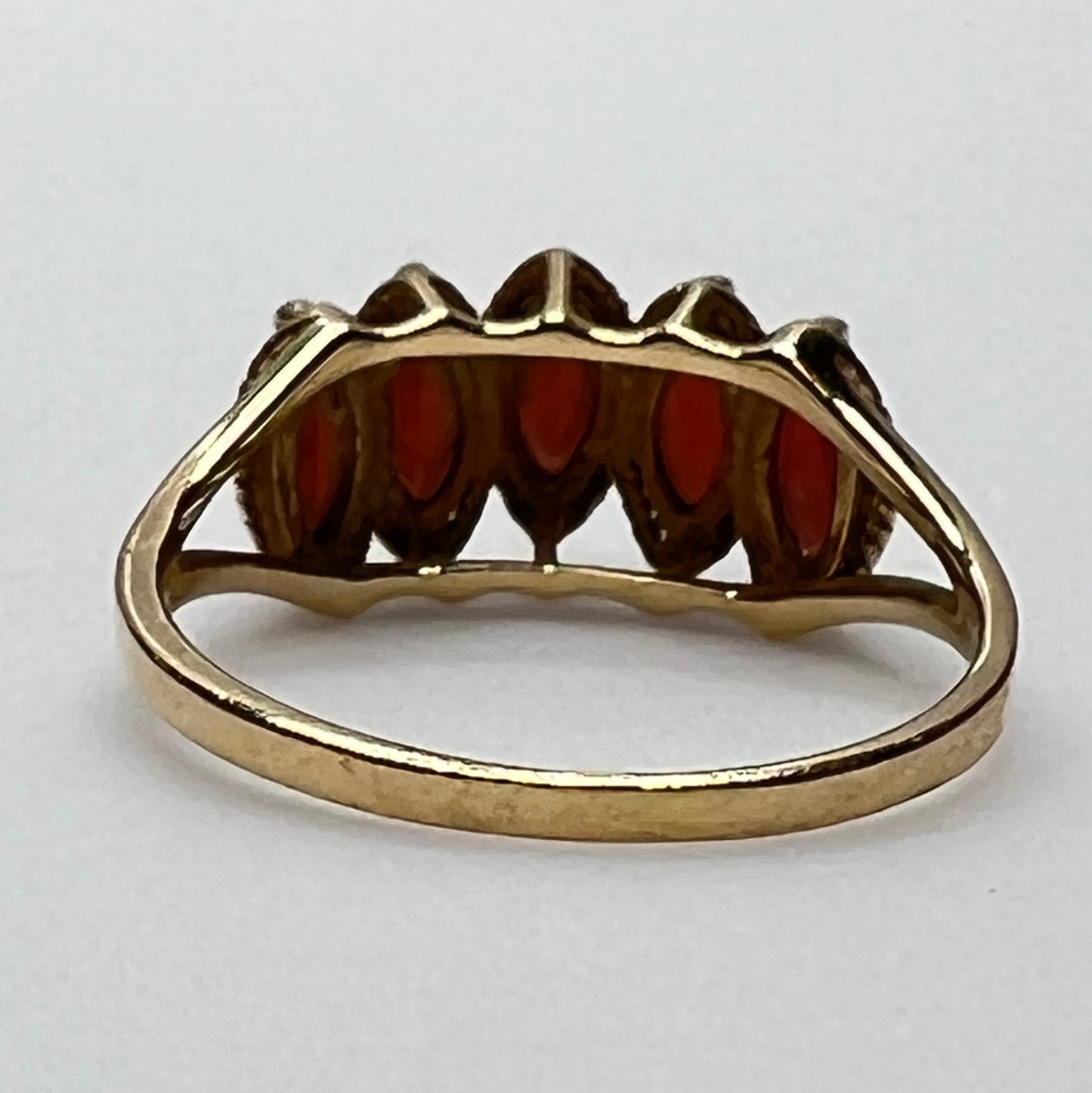 Side view of gold garnet ring showing tiered five-stone setting