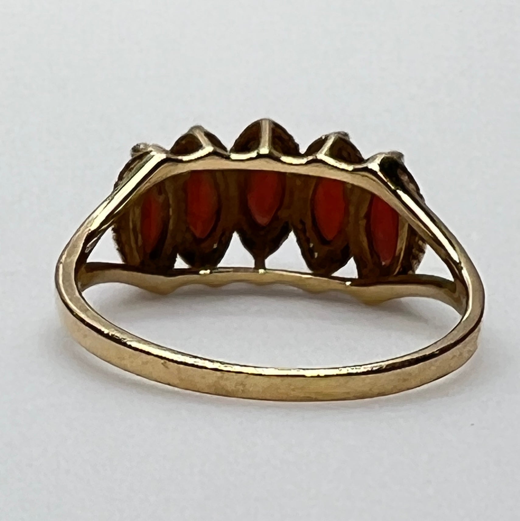 Side view of gold garnet ring showing tiered five-stone setting
