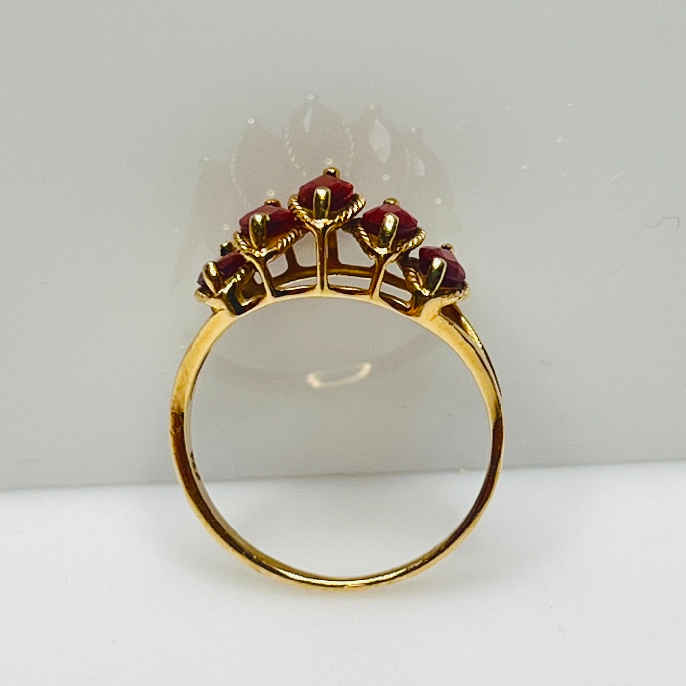 Side view of gold garnet ring showing tiered five-stone setting