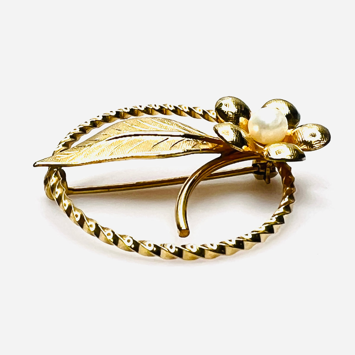 Side view of 1950s gold filled floral brooch with raised genuine pearl