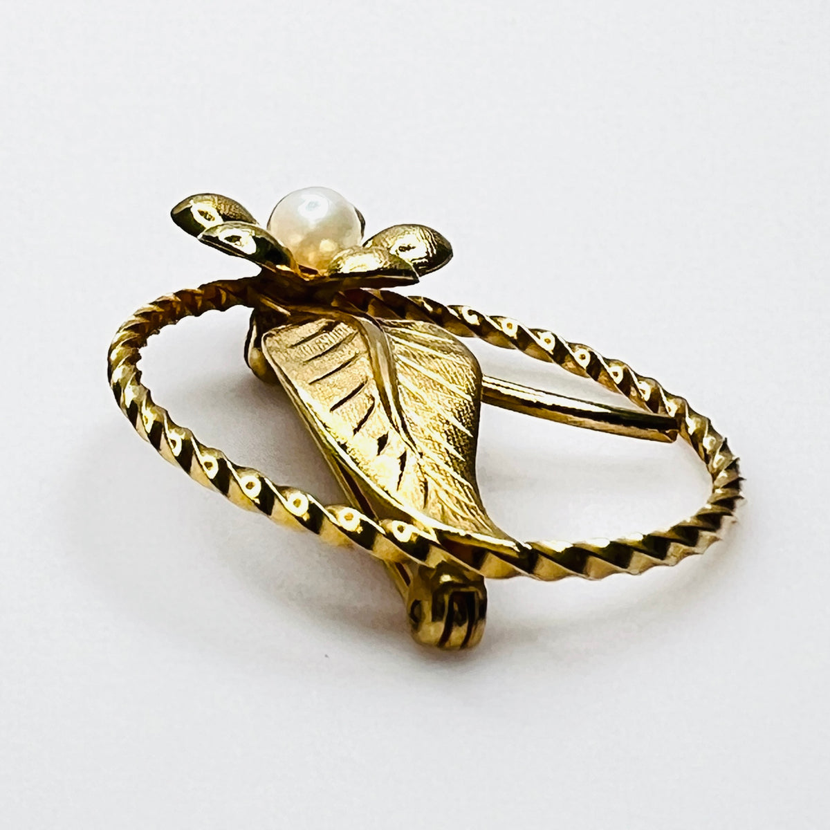 Side view of 1950s gold filled floral brooch with raised genuine pearl