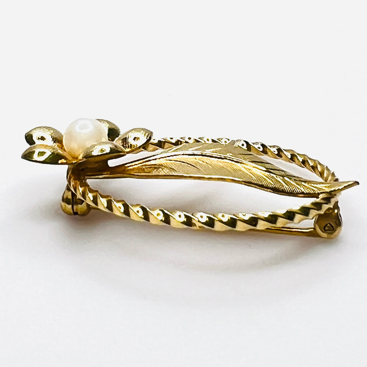 Side view of 1950s gold filled floral brooch with raised genuine pearl
