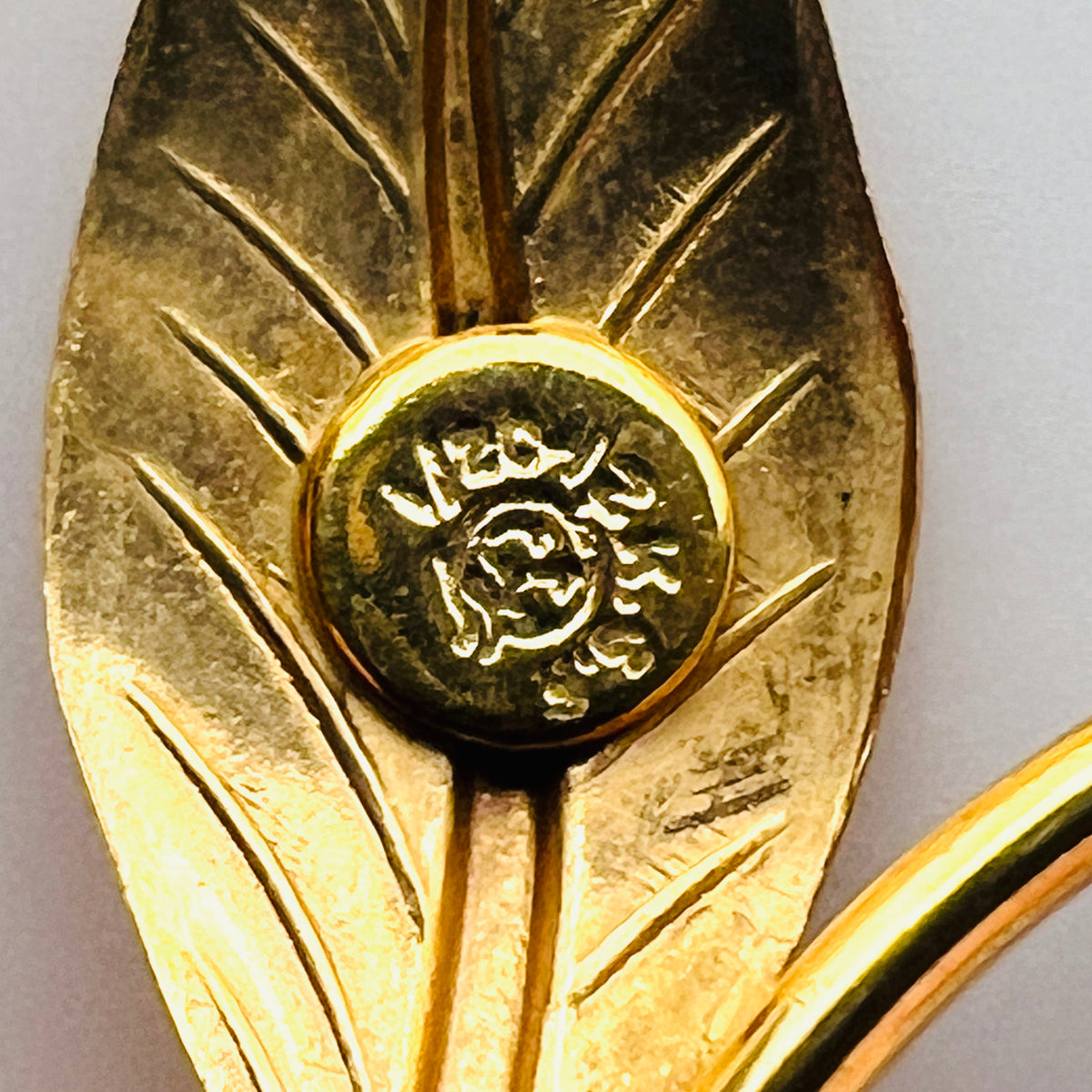 Close-up of maker's symbol on vintage 12K gold filled floral brooch