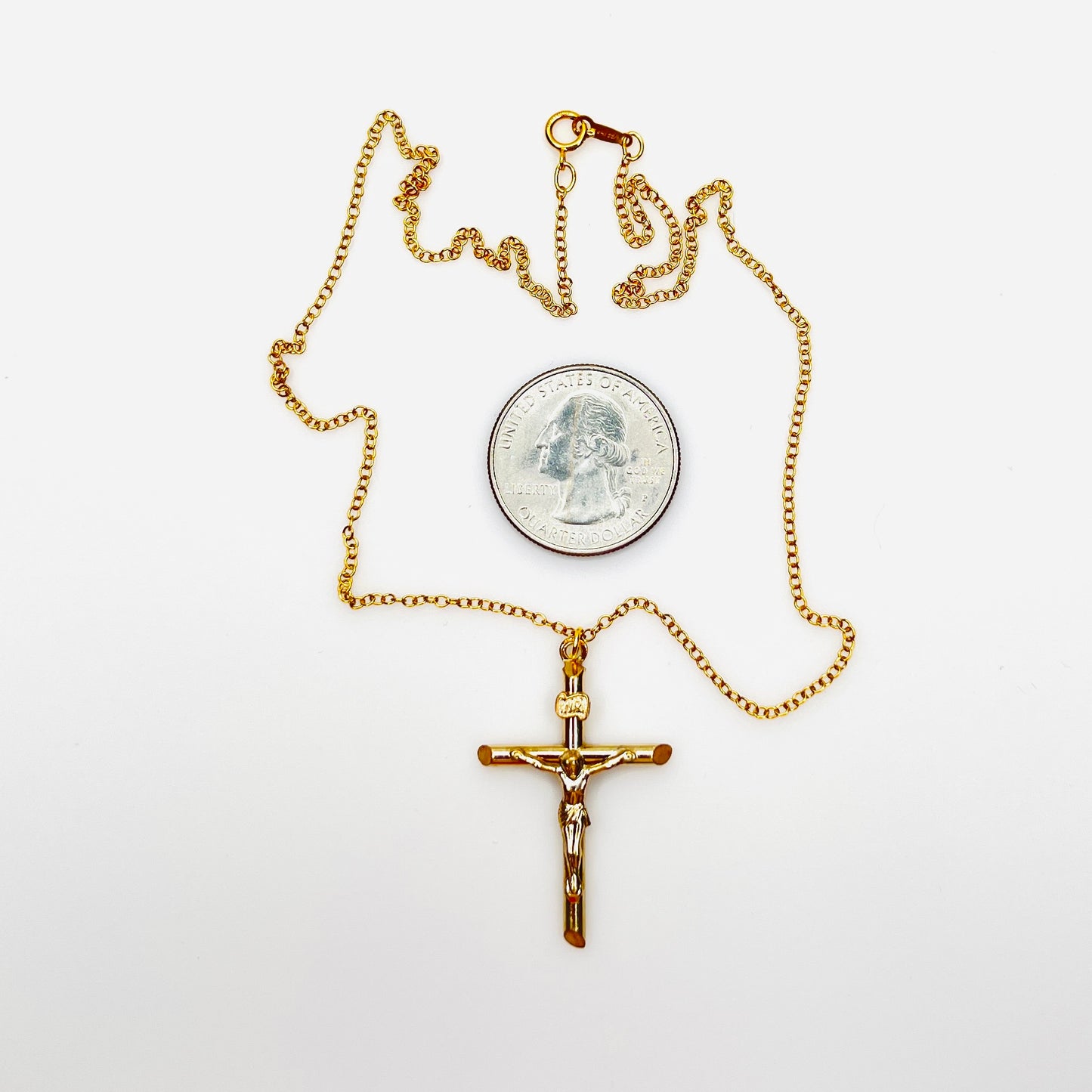 Vintage 14K gold filled crucifix necklace with quarter for size comparison.