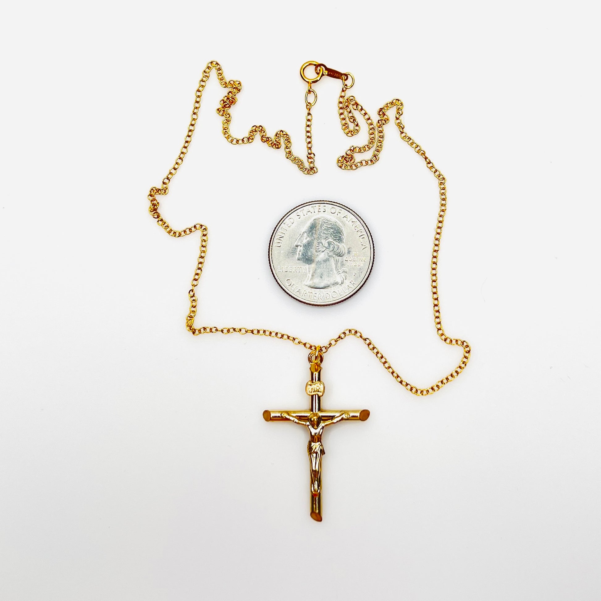 Vintage 14K gold filled crucifix necklace with quarter for size comparison.