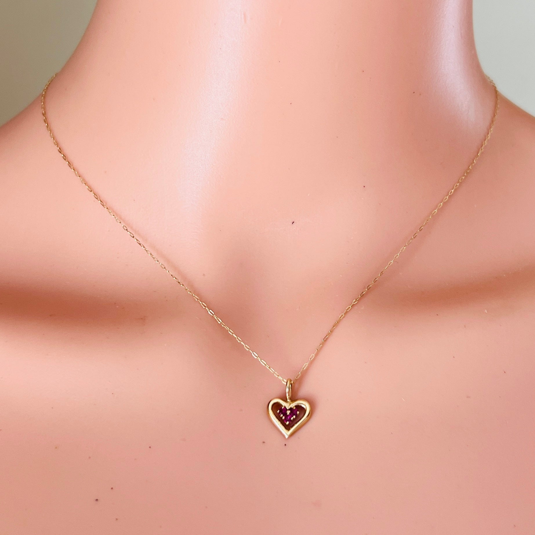 Vintage ruby heart necklace worn on mannequin dainty gold chain