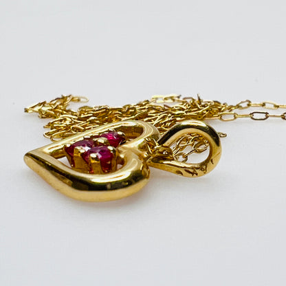 Side view gold heart pendant with ruby stones detail
