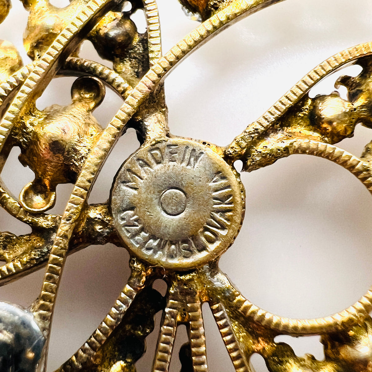 Close-up of the Made in Czechoslovakia stamp and aged gold-tone metal on the brooch reverse.