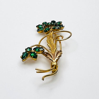 Side view of dimensional 12K gold filled floral brooch with green glass rhinestones
