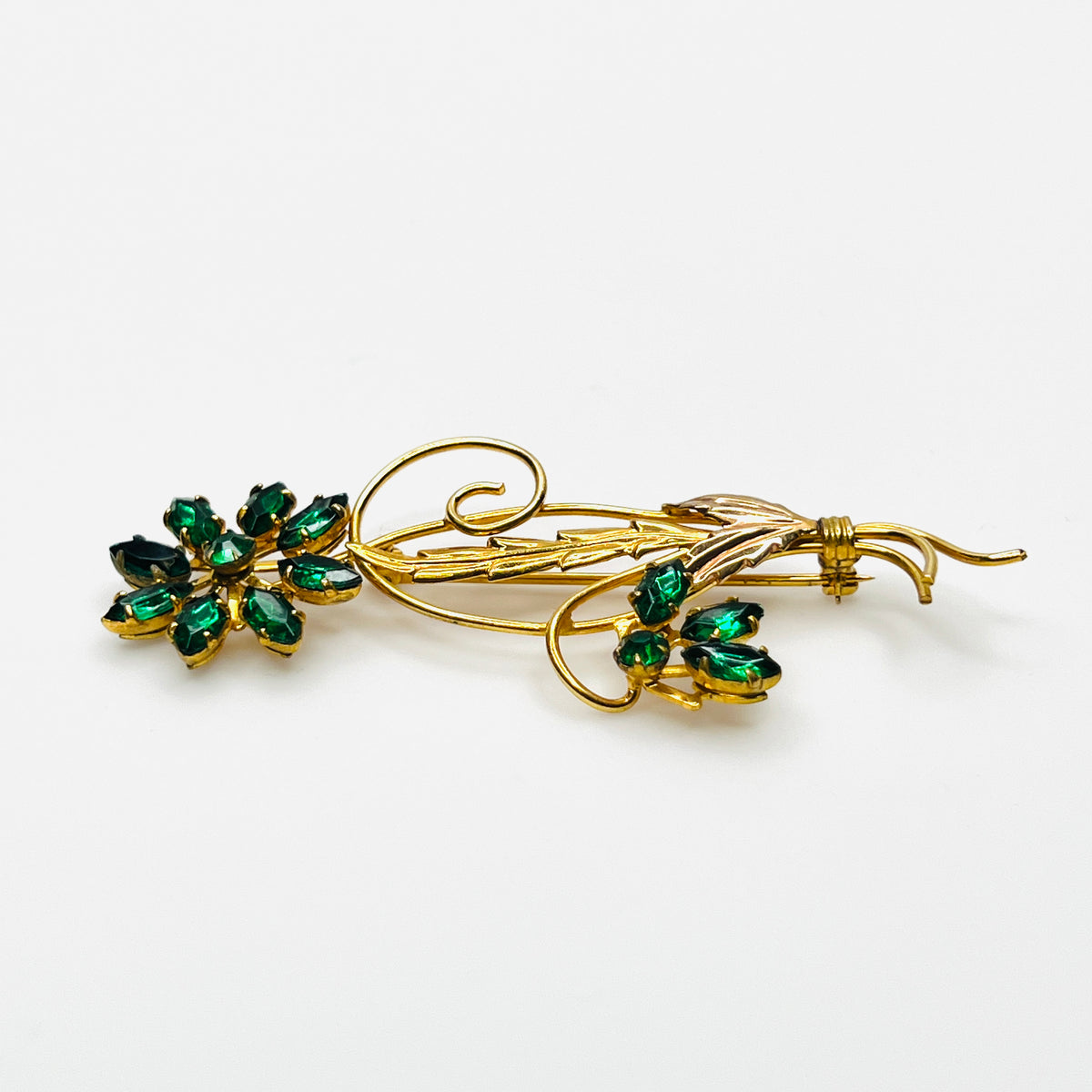 Side view of dimensional 12K gold filled floral brooch with green glass rhinestones