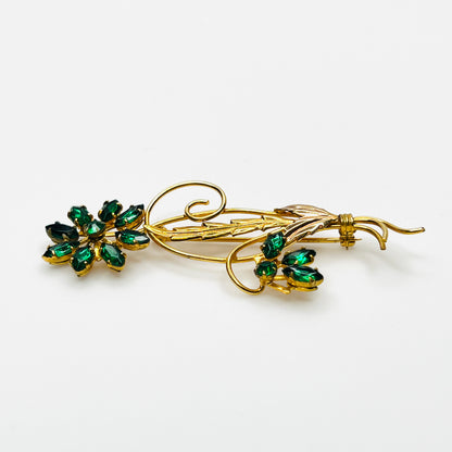 Side view of dimensional 12K gold filled floral brooch with green glass rhinestones