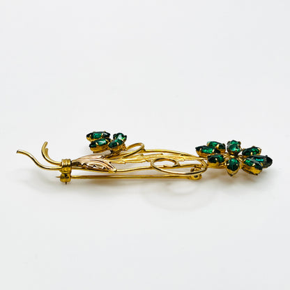 Side view of dimensional 12K gold filled floral brooch with green glass rhinestones