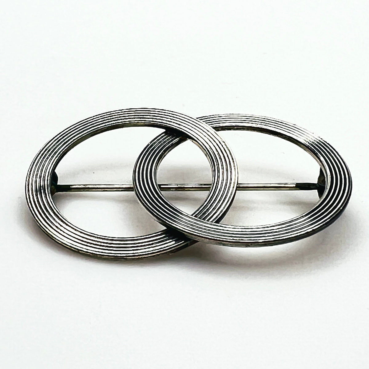 Side view of vintage Beau sterling silver Modernist brooch showing layered circular construction, dimensional profile and pin mechanism.