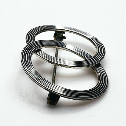 Side view of vintage Beau sterling silver Modernist brooch showing layered circular construction, dimensional profile and pin mechanism.