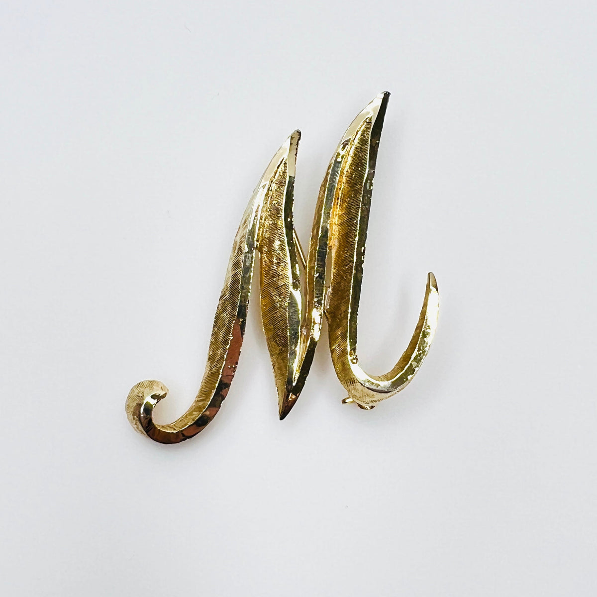 Vintage Mamselle gold tone M or W initial brooch with sculptural curled design