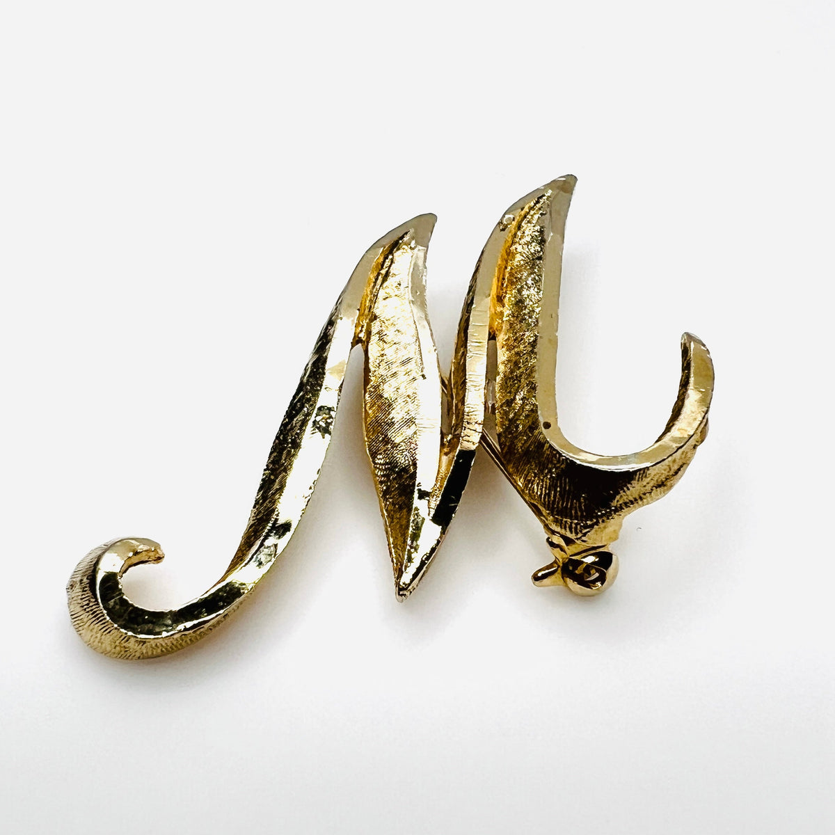 Side view of vintage Mamselle gold tone initial brooch showing dimensional construction