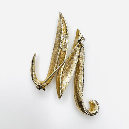 Reverse of signed Mamselle 1960s gold tone M or W initial brooch with pin closure