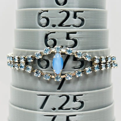 Blue rhinestone bracelet with marquise moonstone centerpiece displayed on bracelet sizer