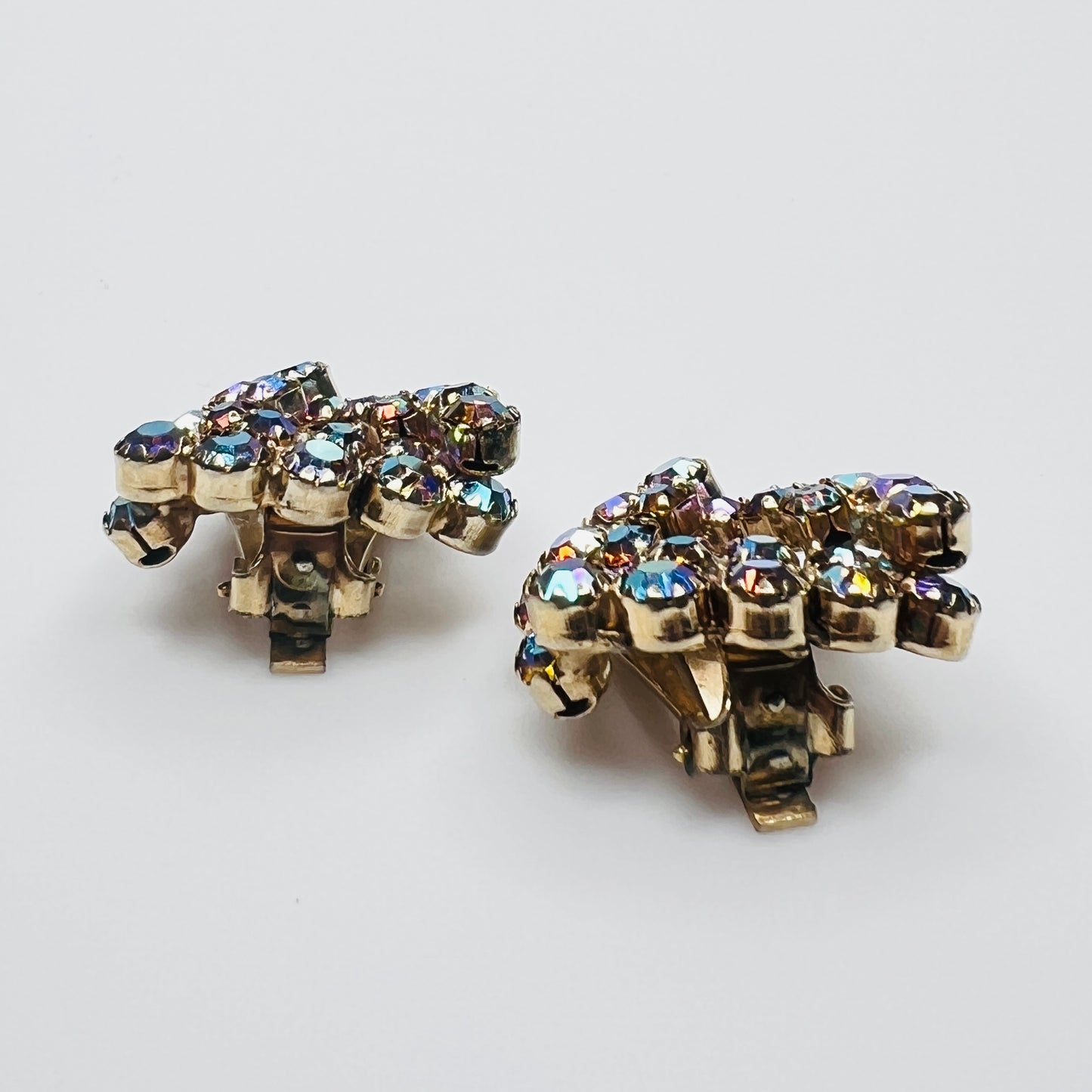 Side view of vintage amber aurora borealis rhinestone clip-on earrings.