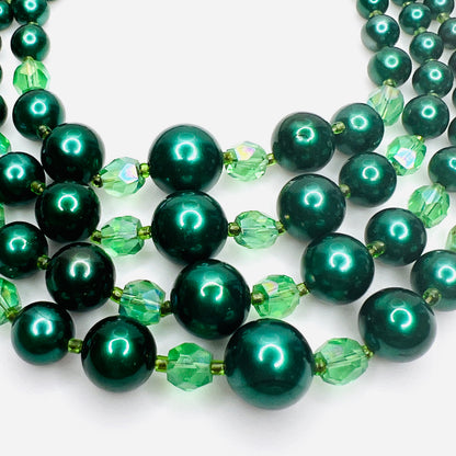 Close view of emerald green faux pearls and crystal bead accents