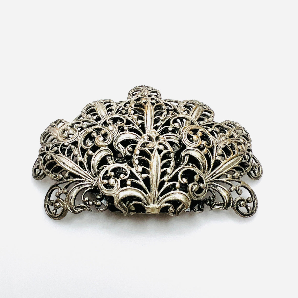 Vintage 1950s silver tone fleur-de-lis filigree brooch with ornate layered scrollwork