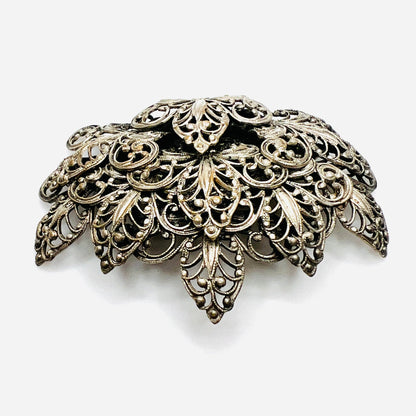 Side view of vintage silver tone filigree brooch showing dimensional layered construction