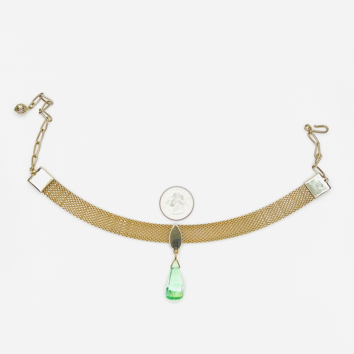 Vintage 1950s mesh choker necklace with green crystal drop and adjustable chain with quarter for scale. 