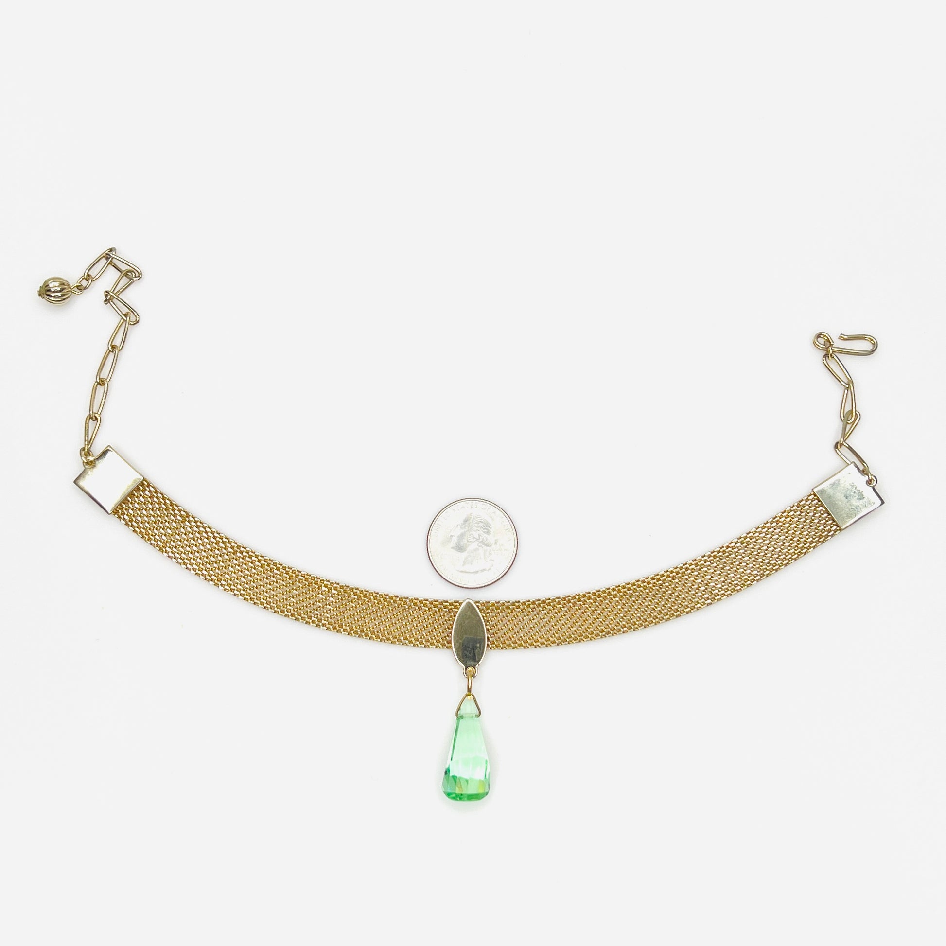 Vintage 1950s mesh choker necklace with green crystal drop and adjustable chain with quarter for scale. 