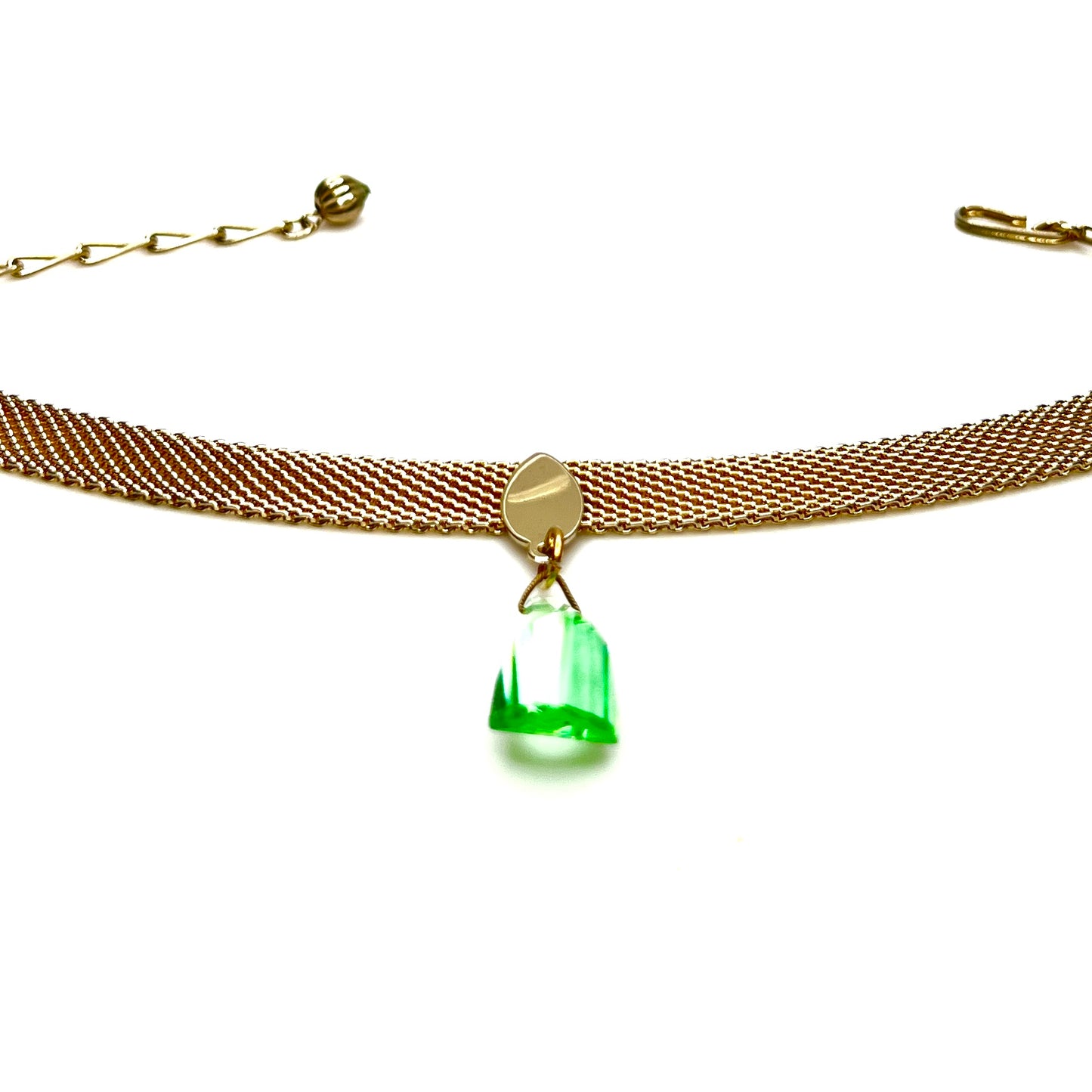 Vintage gold tone mesh choker necklace displayed flat showing green crystal pendant detail