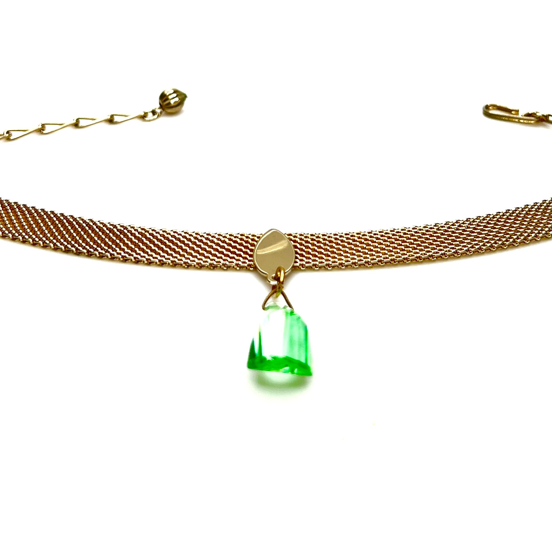 Vintage gold tone mesh choker necklace displayed flat showing green crystal pendant detail