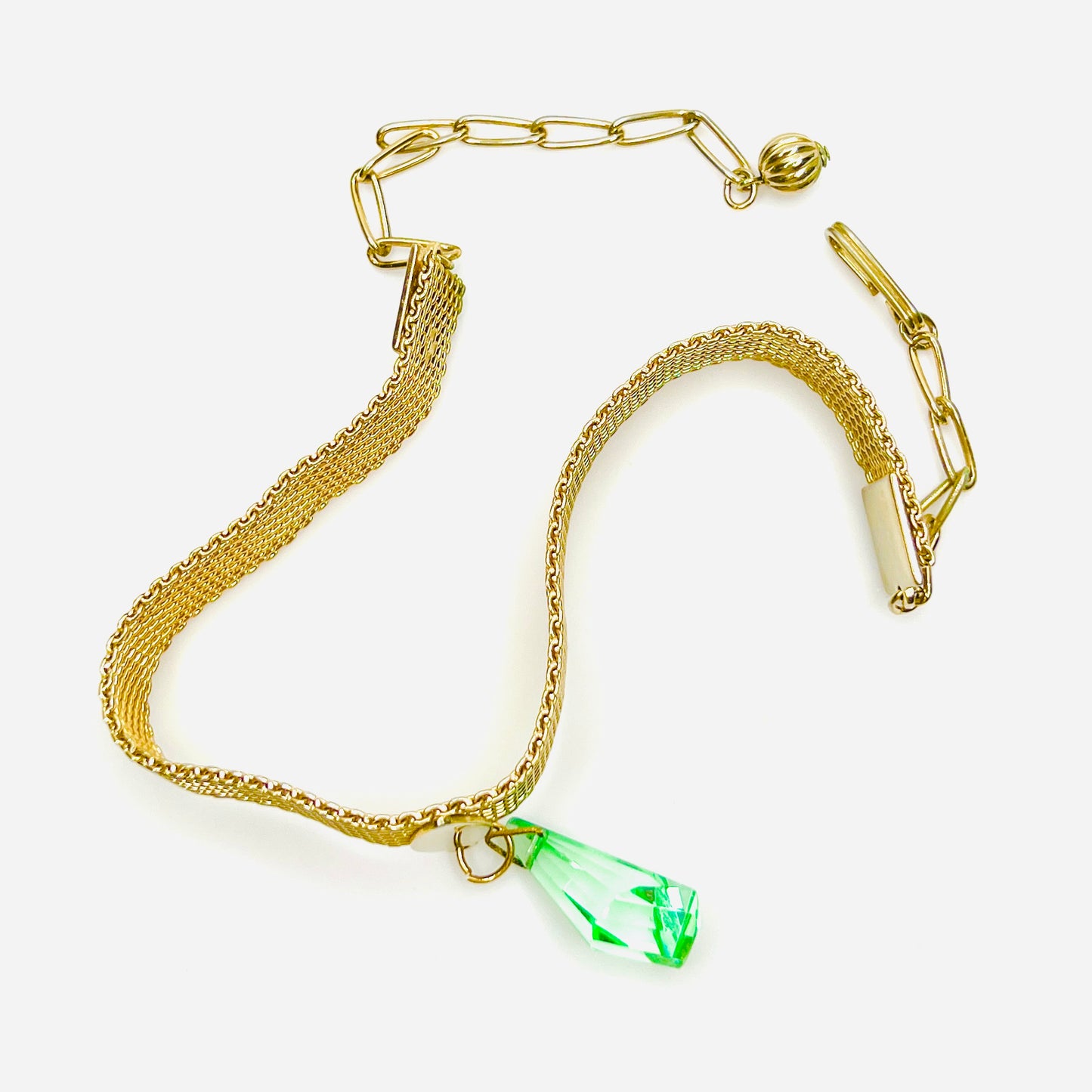 Close-up of vintage 1950s mesh choker necklace with green crystal drop and adjustable chain