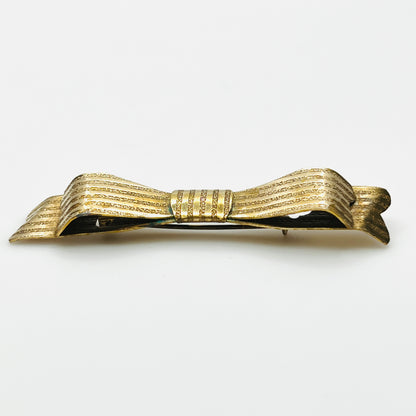 Side view of 1950s textured gold-tone bow pin showing layered ribbon loops and dimensional construction