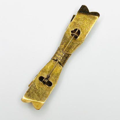 Reverse of unsigned vintage 1950s gold-tone ribbon bow brooch showing traditional C-clasp pin closure