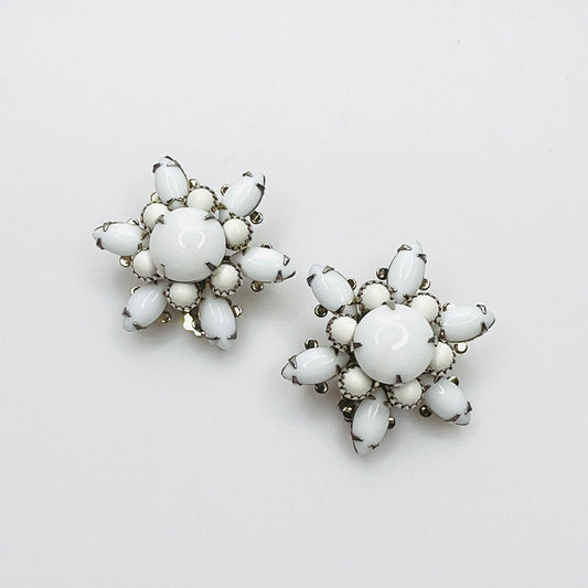 Vintage 1950s white milk glass flower clip-on earrings with floral cluster design.