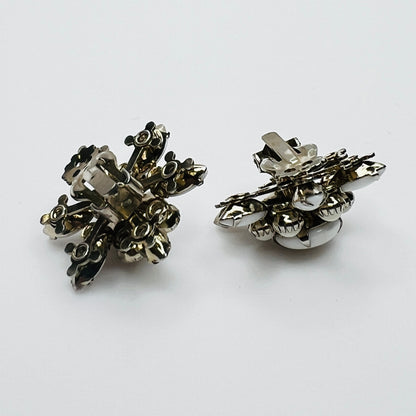 Side view of vintage milk glass flower clip-on earrings in silver-tone setting.