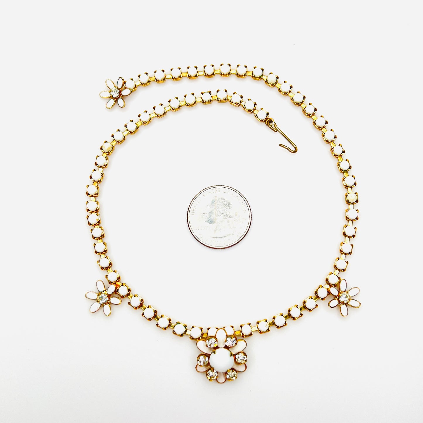 1950s adjustable milk glass flower choker necklace shown beside quarter for scale.