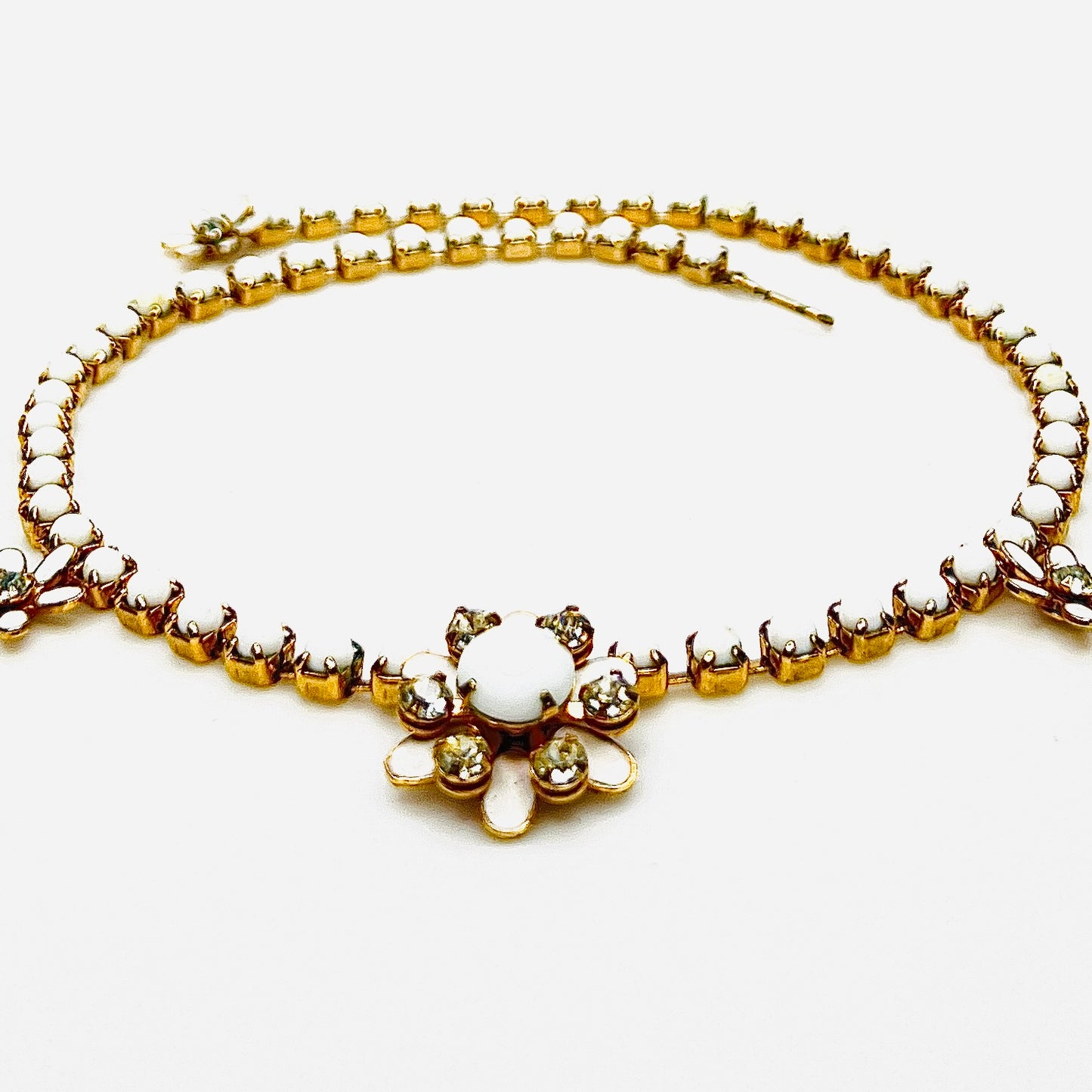 Side view of vintage milk glass and rhinestone floral choker necklace.