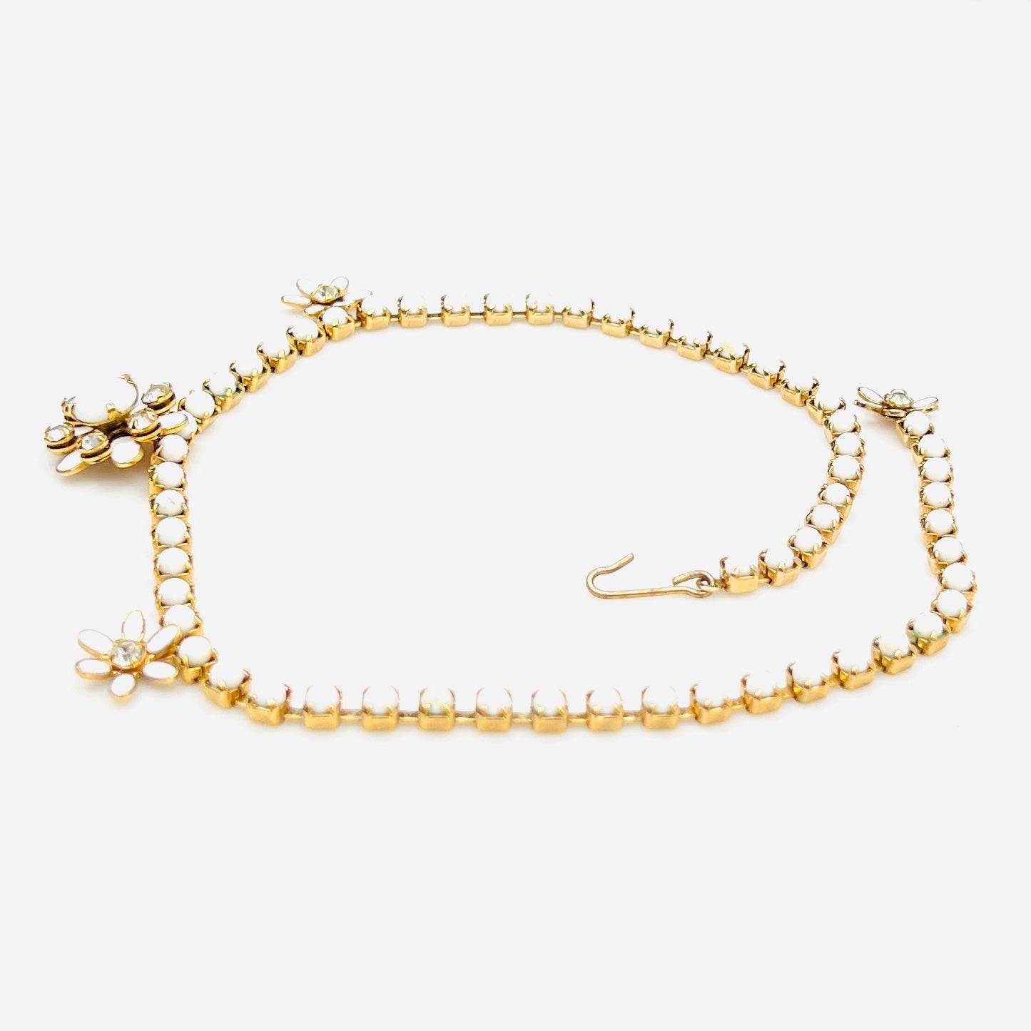 Side view of vintage milk glass and rhinestone floral choker necklace.