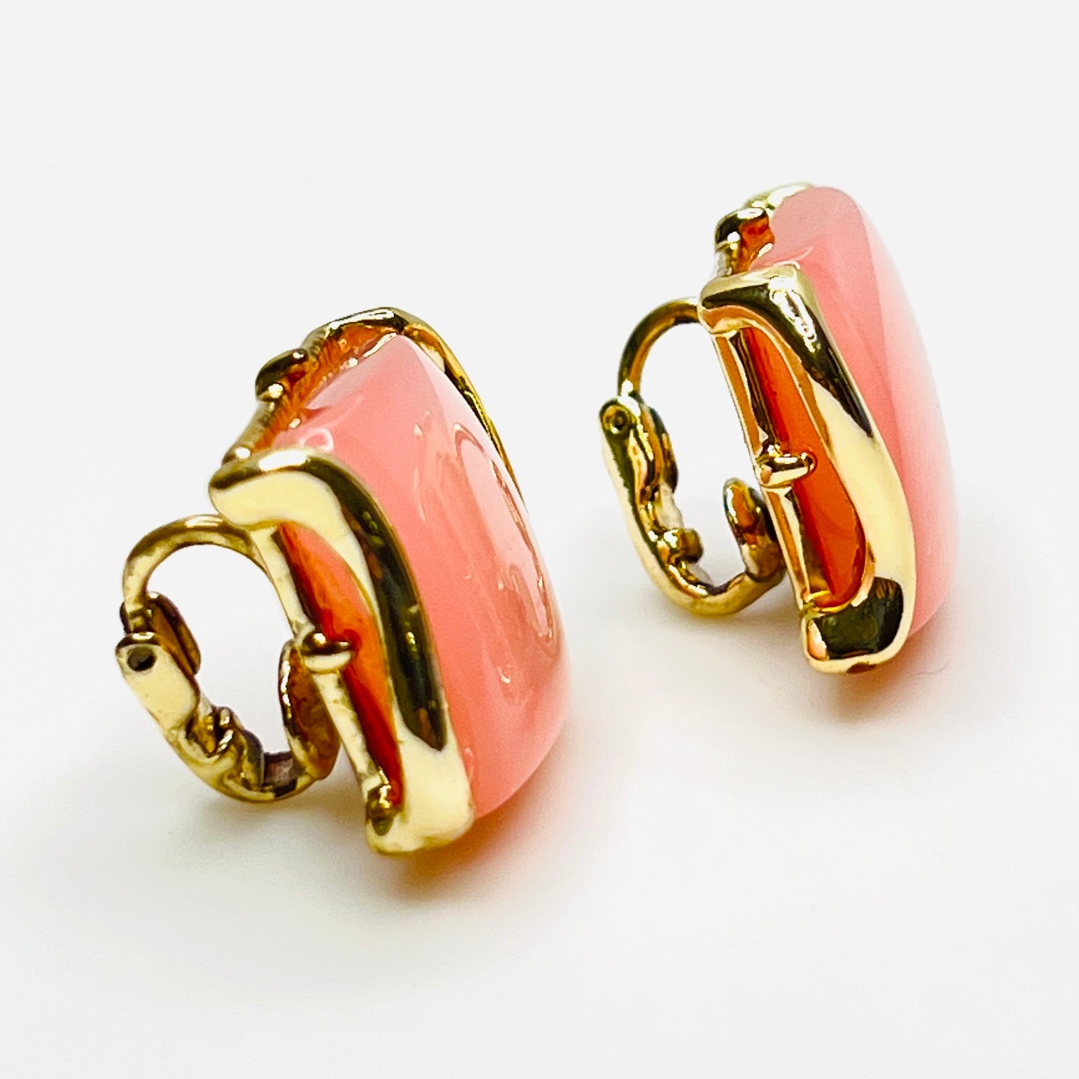 Side view of vintage pink thermoset Lucite clip-on earrings in gold-tone metal