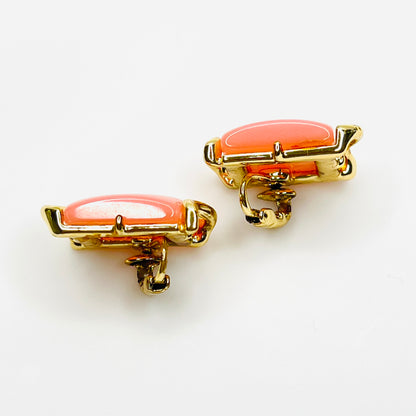 Side view of vintage pink thermoset Lucite clip-on earrings in gold-tone metal