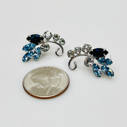 Mid-century blue and clear rhinestone earrings beside quarter for scale