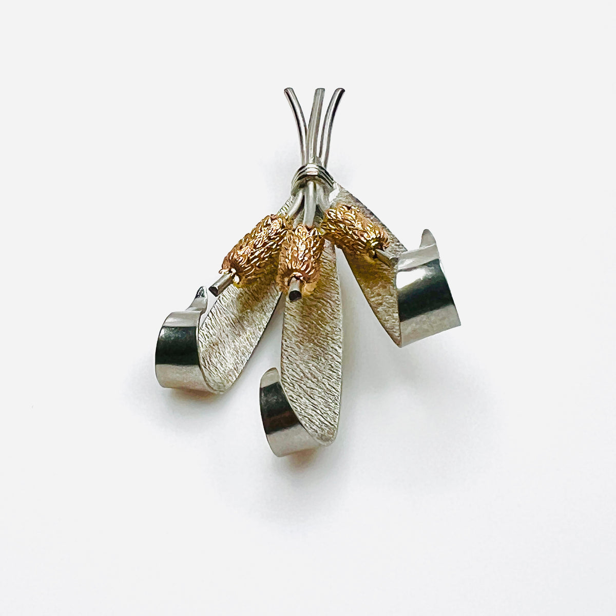 Side view of vintage two-tone cattail brooch showing dimensional metal construction