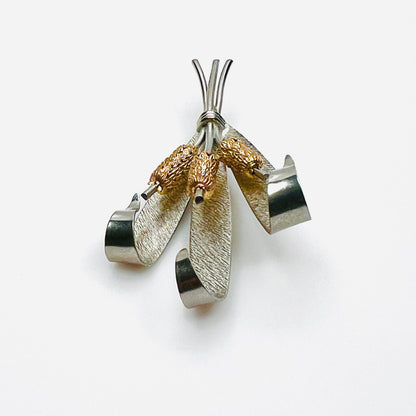 Side view of vintage two-tone cattail brooch showing dimensional metal construction