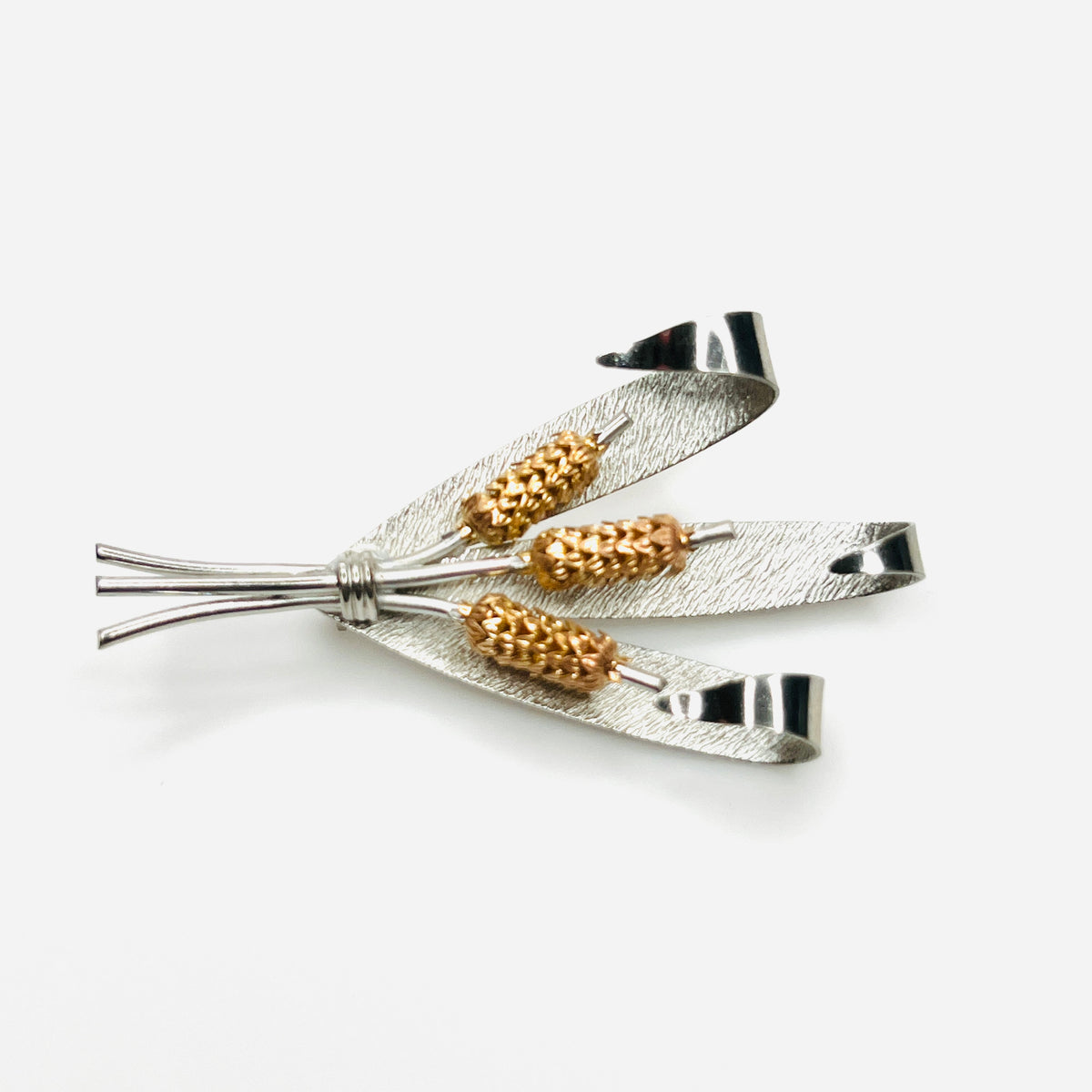 Side view of vintage two-tone cattail brooch showing dimensional metal construction