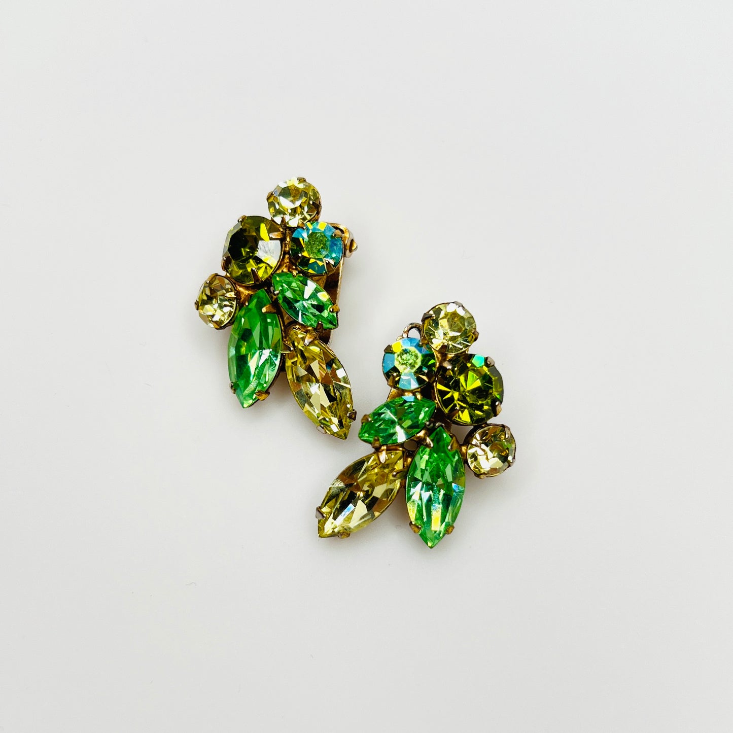 Vintage 1950s uranium glass rhinestone clip-on earrings with green crystal spray design.