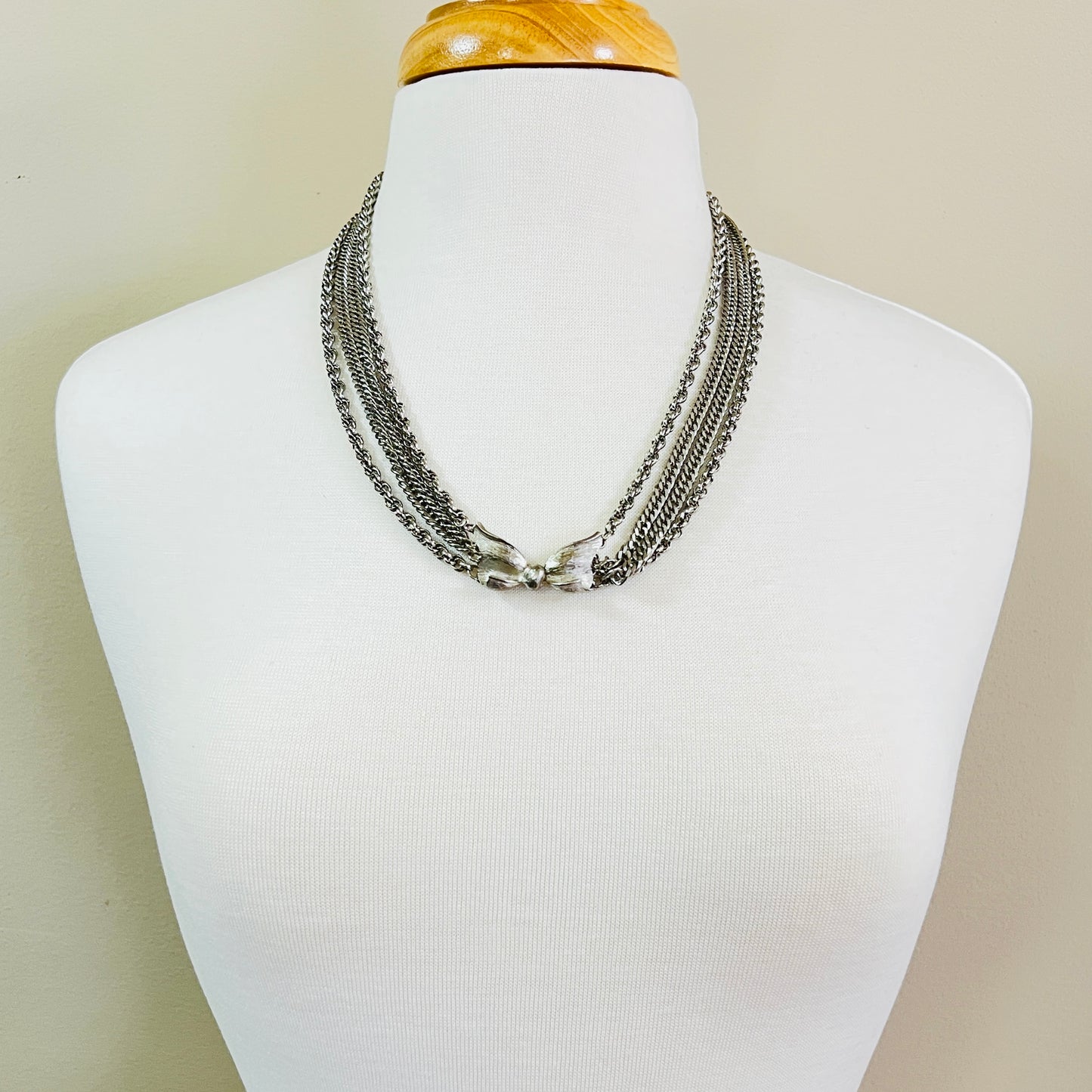 Necklace worn on mannequin showing layered silver chains