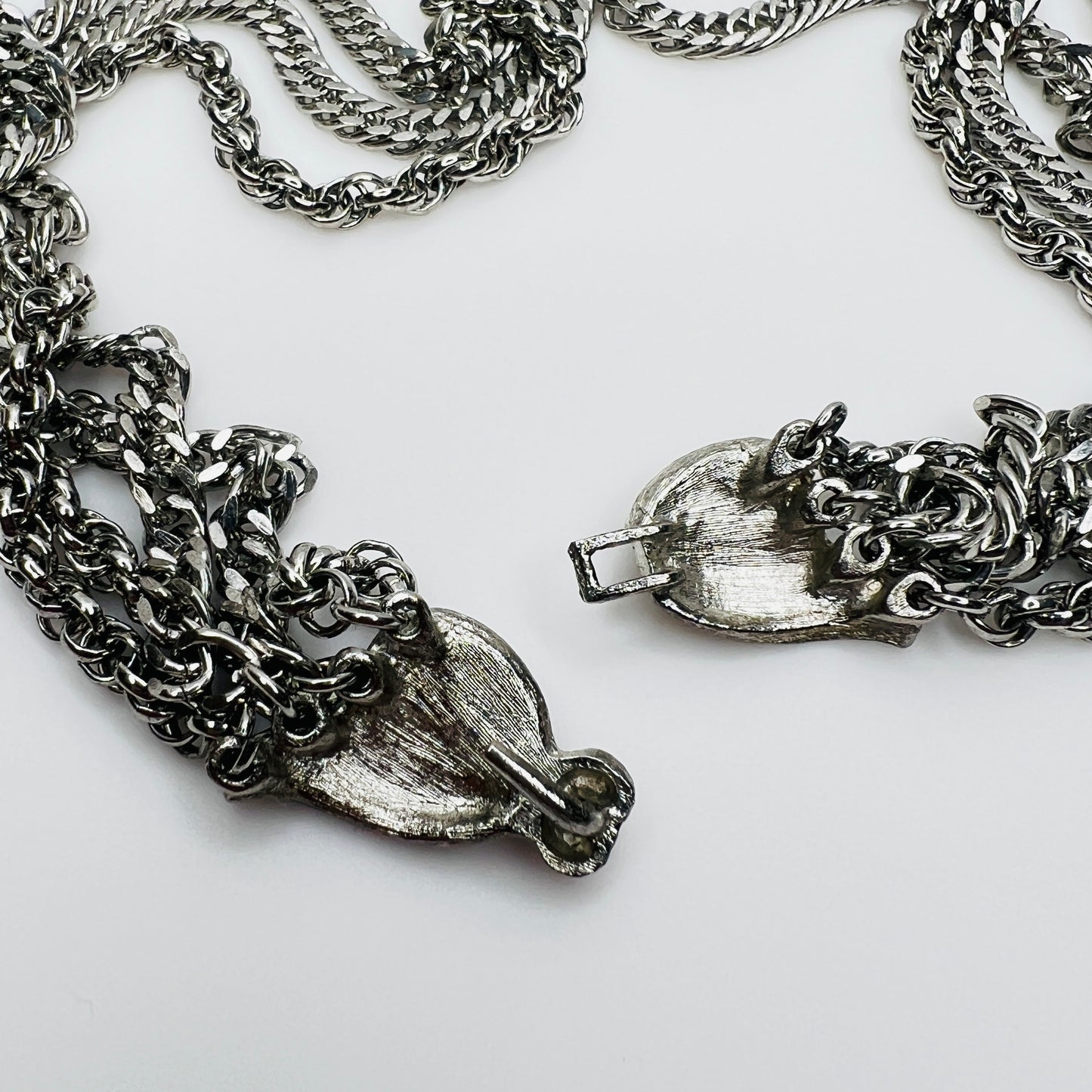 Close-up of brushed silver bow clasp on vintage necklace