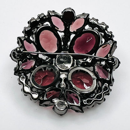 Reverse of Juliana brooch showing open-backed rhinestone settings, pooled solder construction, and pin closure.