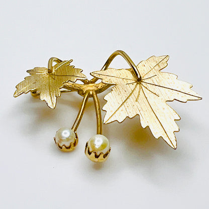 Side view of Sarah Coventry gold tone maple leaf brooch showing dimensional leaves and pearl settings